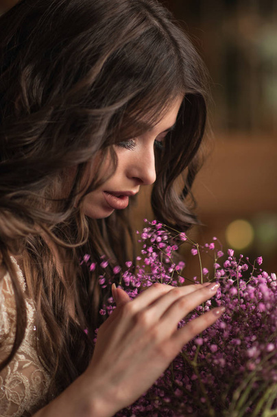 Beautiful brunette girl with a bouquet of flowers close-up - Fotografie, Obrázek