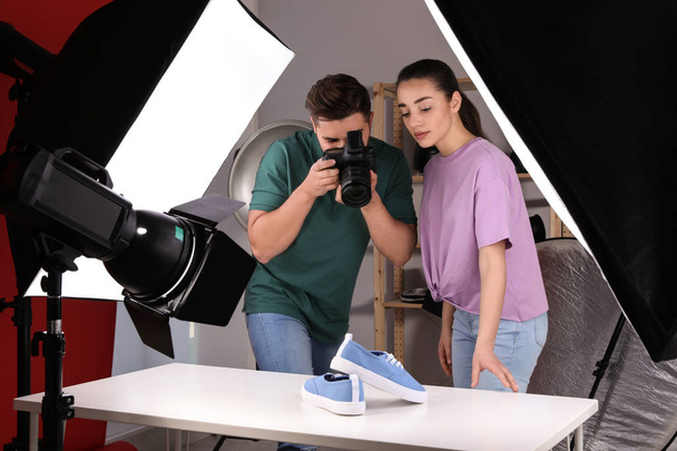 Επαγγελματίες φωτογράφοι γυρίσματα μοντέρνα παπούτσια στο στούντιο - Φωτογραφία, εικόνα