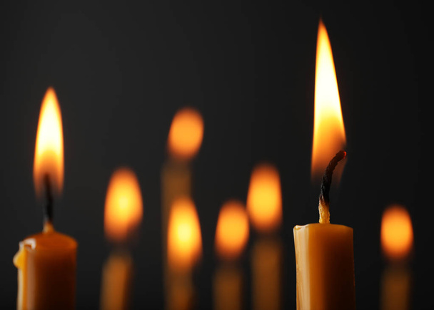 Burning candles on dark background, space for text. Symbol of sorrow - Фото, изображение