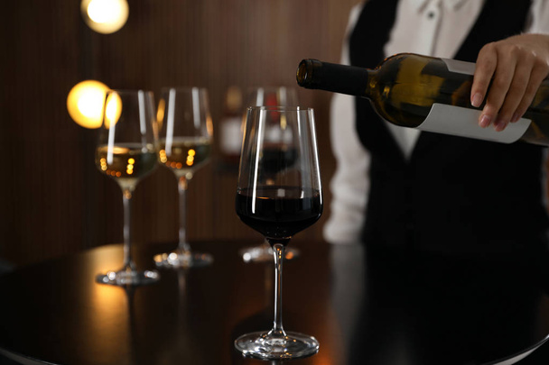 Waitress pouring wine into glass in restaurant, closeup - Foto, immagini