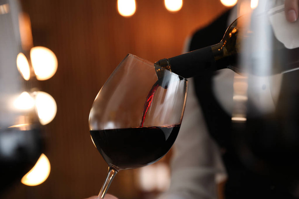 Waitress pouring wine into glass in restaurant, closeup - Foto, immagini