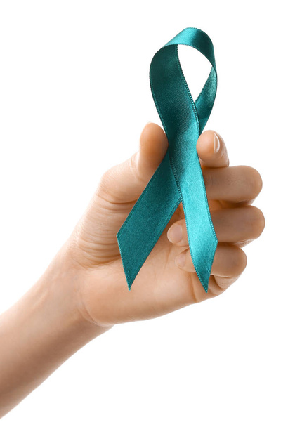 Woman holding teal awareness ribbon against white background, closeup - Foto, imagen