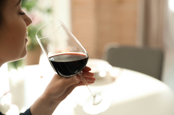 Woman with glass of wine in restaurant, closeup. Space for text - Foto, afbeelding