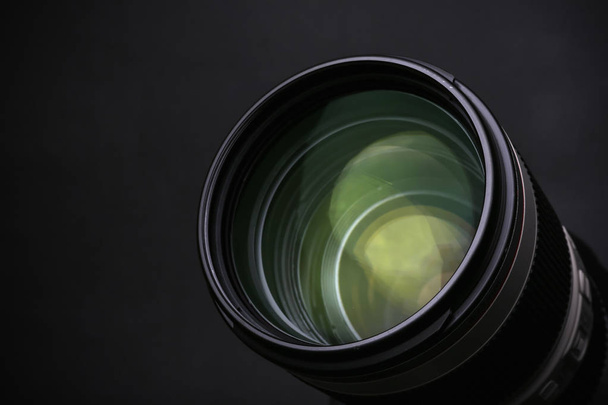 Modern camera lens on black background, closeup. Space for text - Foto, imagen