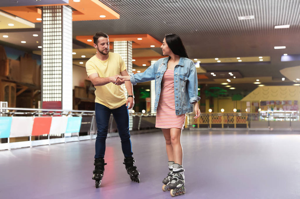 Young couple spending time at roller skating rink - Φωτογραφία, εικόνα