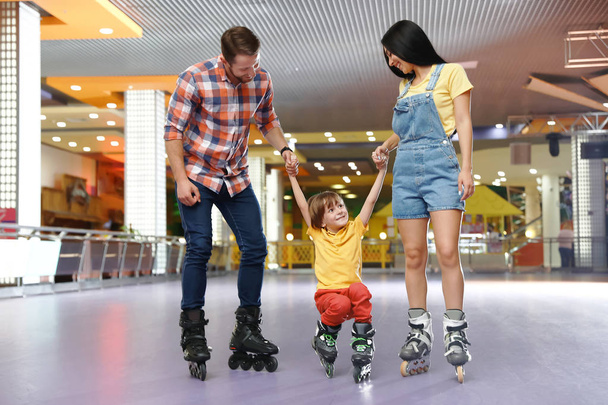 Happy family spending time at roller skating rink - Fotoğraf, Görsel