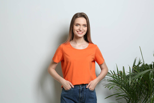 Young woman wearing blank t-shirt on light background. Mockup for design - Foto, Imagen