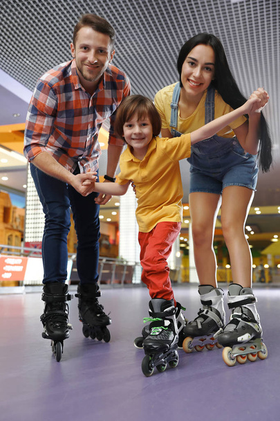 Happy family spending time at roller skating rink - Foto, Imagen