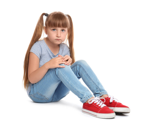 Full length portrait of little girl with knee problems sitting on white background - Φωτογραφία, εικόνα