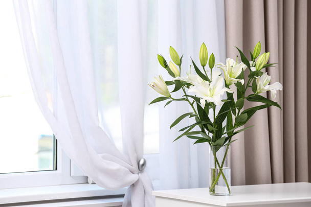 Vase with bouquet of beautiful lilies on white table indoors. Space for text - Fotoğraf, Görsel