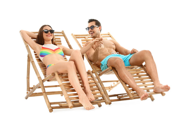 Young couple on sun loungers against white background. Beach accessories - Фото, изображение