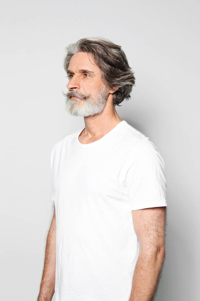 Portrait of charming mature man on light grey background - Fotó, kép