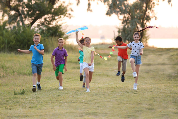 Cute little children playing with kite outdoors - Fotó, kép