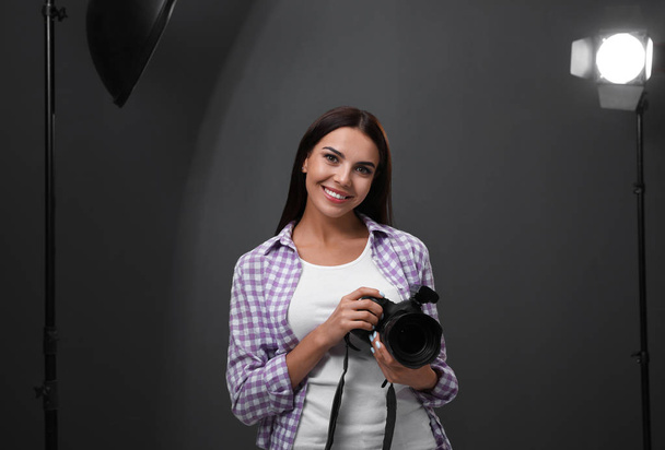 Professional photographer with modern camera in studio - Photo, Image