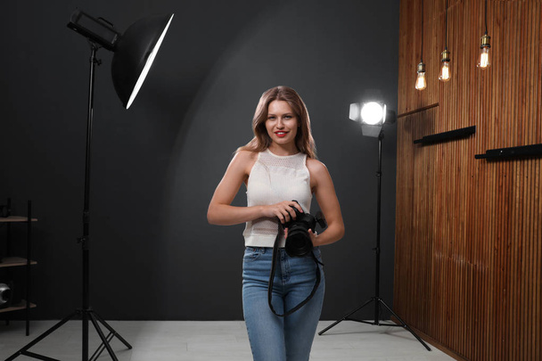 Professional photographer with modern camera in studio - Foto, afbeelding