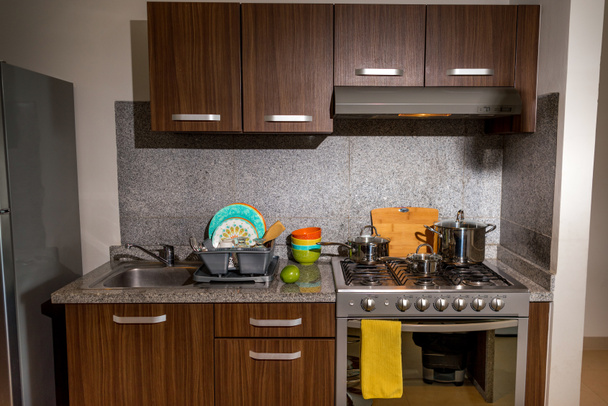 Современная кухня с кухней и всем необходимым для приготовления пищи. Кухонная мебель
. - Фото, изображение