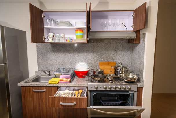 Современная кухня с кухней и всем необходимым для приготовления пищи. Кухонная мебель
. - Фото, изображение