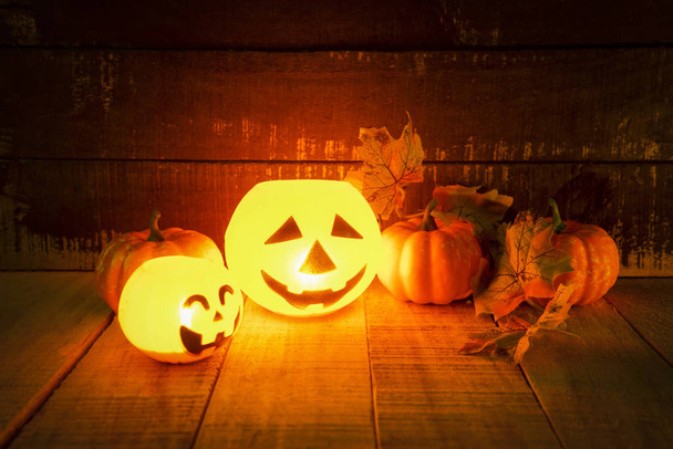 Halloween pumpkin lantern with dry leaves autumn on wooden - hea - Photo, Image