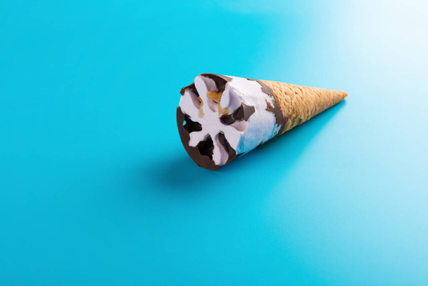 вид сбоку Конус мороженого со вкусом сладкого картофеля на синем фоне
 - Фото, изображение