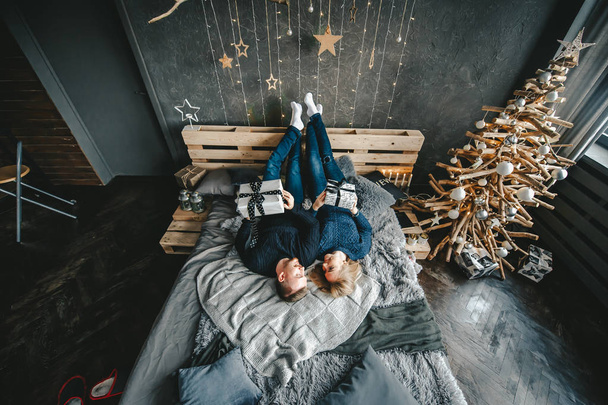 Πορτραίτο μιας ευτυχης γυναίκας και ενός άντρα ξαπλωμένο στο κρεβάτι που αναπαύεται μαζί στο σπίτι. Κορυφαία προβολή - Φωτογραφία, εικόνα