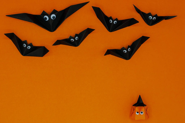 L'origami Halloween fond de citrouille tête jack-o-lanterne regarder les chauves-souris volantes
. - Photo, image