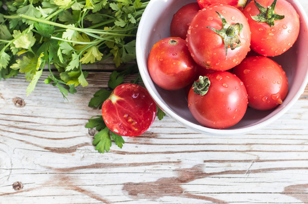 Fresh tomatos and herbs on wooden background. Summer salad. - 写真・画像
