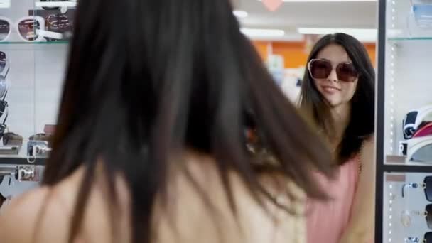das Mädchen vor dem Spiegel probiert eine Sonnenbrille an - Filmmaterial, Video