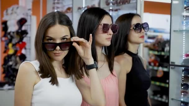 Νεαρά κορίτσια αγοράζουν γυαλιά ηλίου σε μια μικρή μπουτίκ. - Πλάνα, βίντεο