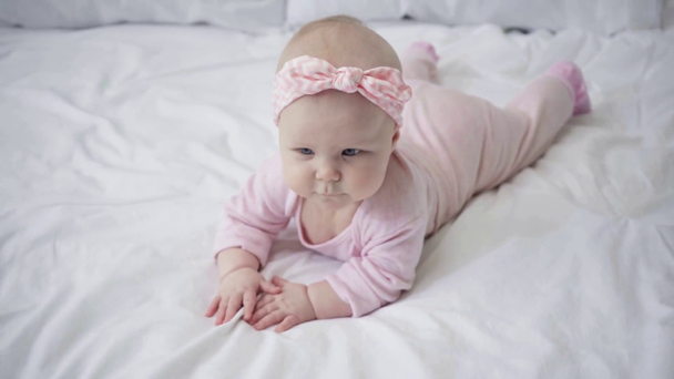 вибірковий фокус милого немовляти лежить на ліжку
  - Кадри, відео