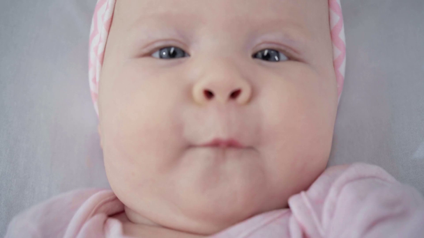 bovenaanzicht van schattige baby gebaren in bed  - Video