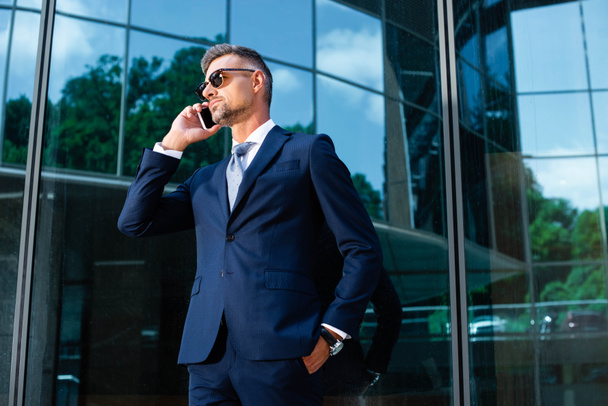 handsome man in suit and glasses talking on smartphone  - Foto, Imagem