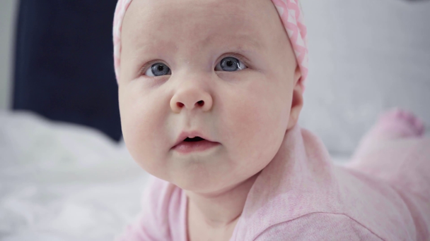 Focus pull de bébé mignon roulant sur le lit
  - Séquence, vidéo