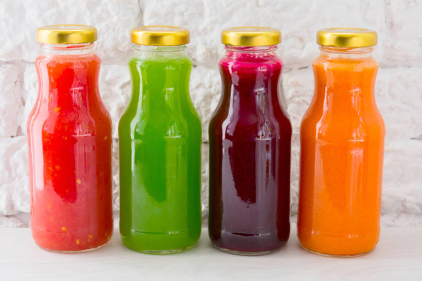  Vier groentesappen in glazen flessen. Een groot plan. Het concept van gezond eten. - Foto, afbeelding