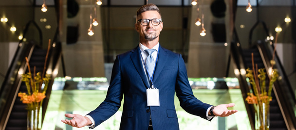 panoramic shot of handsome businessman in suit and glasses with outstretched hands - Photo, Image