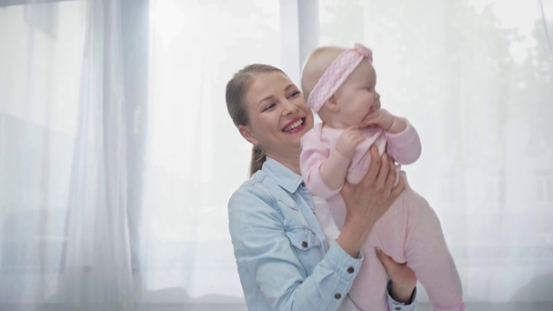 ευτυχισμένη μητέρα κρατώντας στα χέρια χαριτωμένο μωρό κόρη  - Πλάνα, βίντεο