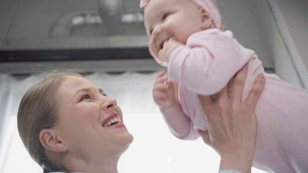 vue à angle bas de la mère tenant dans les bras bébé gai
  - Séquence, vidéo