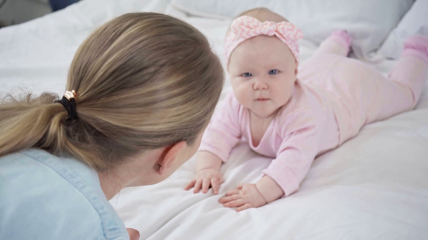 Fokuszug der Mutter beim Anblick des auf dem Bett liegenden Säuglings  - Filmmaterial, Video