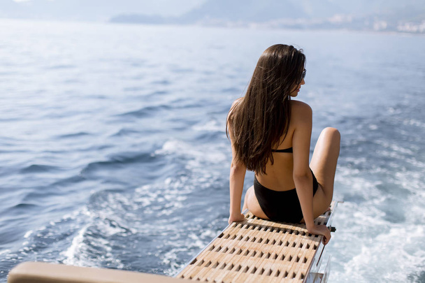 Ładna młoda kobieta z okulary słoneczne relaks na jachcie na morzu w słoneczny dzień - Zdjęcie, obraz