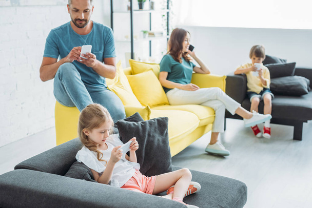 családi ül kanapék és használata okostelefonok együtt otthon - Fotó, kép