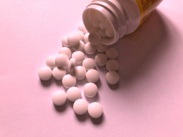 Pillen op een roze achtergrond. Medische verzorging en behandeling - Foto, afbeelding
