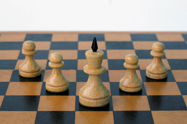 Rey de ajedrez blanco en el centro y peones blancos alrededor
 - Foto, Imagen