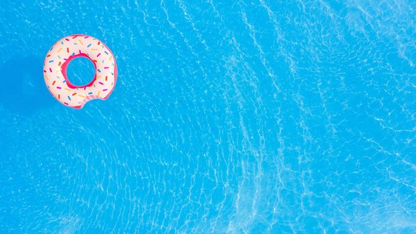 Summer Vacation. Aerial view of big pink donut in the swimming pool. - Fotó, kép
