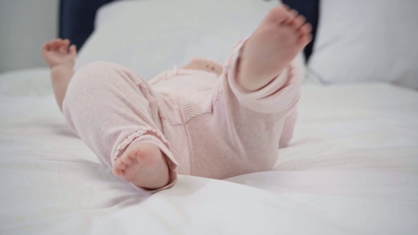 селективное внимание милого младенца, движущегося ногами на кровати
  - Кадры, видео