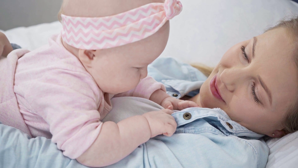enfoque selectivo del bebé tocando la ropa de la madre
  - Imágenes, Vídeo