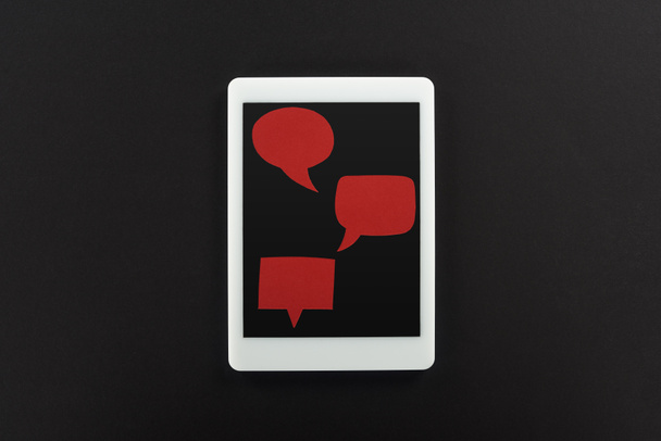 visão superior do tablet digital com bolhas de fala vermelhas vazias no fundo preto, conceito de cyberbullying
 - Foto, Imagem