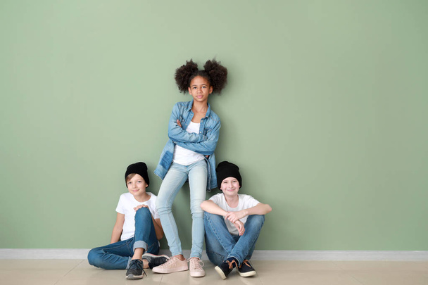 Стильные дети в джинсах одежда рядом с цветной стеной
 - Фото, изображение