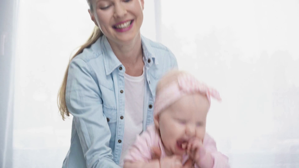 fröhliche Mutter schaukelt süße Baby-Tochter  - Filmmaterial, Video