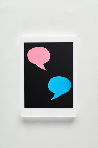 верхний вид цифрового планшета с пустыми пузырями речи на экране на белом фоне, концепция киберзапугивания
 - Фото, изображение