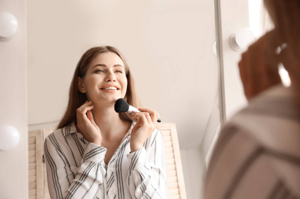 Jovem mulher perto do espelho na sala de maquiagem
 - Foto, Imagem