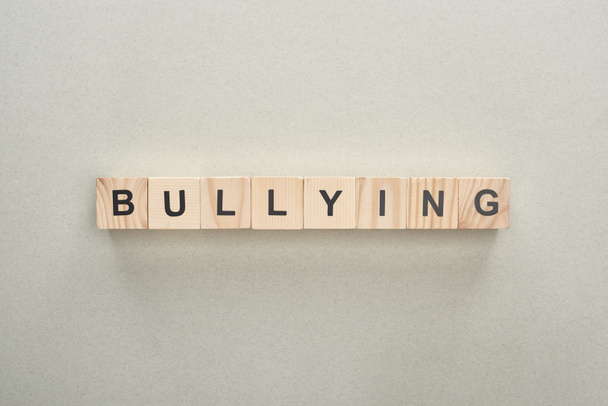 top view of wooden blocks with bullying lettering on grey background - Foto, imagen